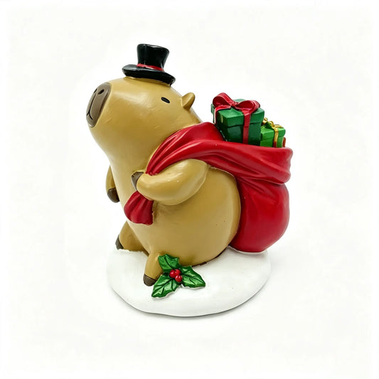 hand-painted Christmas capybara figurine with black top hat, red sack, and holly berry snow base on white background