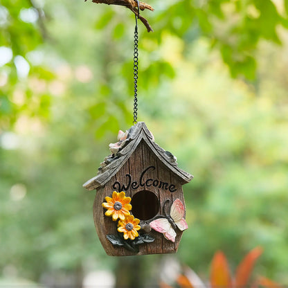 Welcome birdhouse with floral roof accent hanging from branch