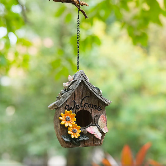 Welcome birdhouse with floral roof accent hanging from branch