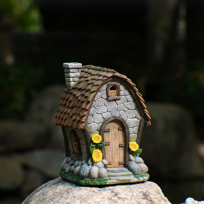 Hand-painted sunflower stone cottage fairy house front view on rock in outdoor garden