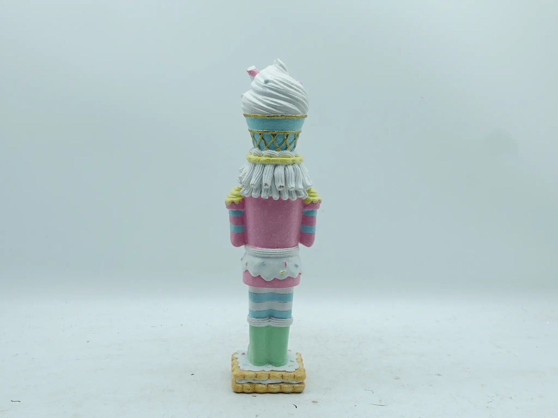 Back view of the candyland nutcracker figurine showing striped uniform and frosting details