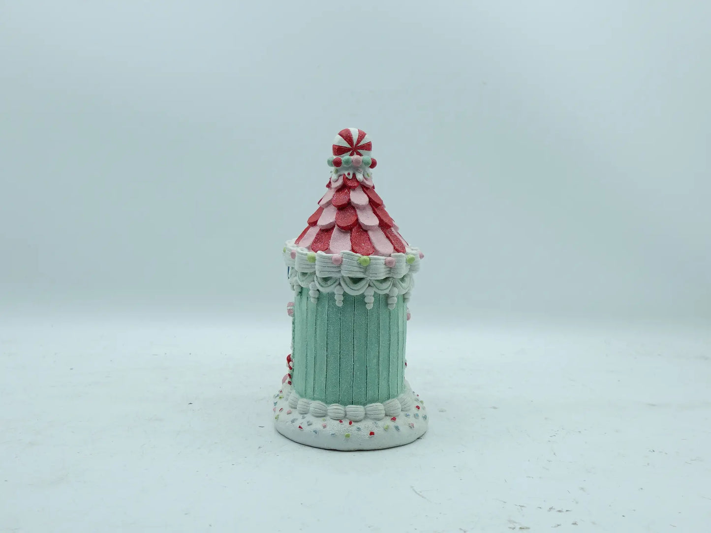 Back view of the gingerbread house ornament showing mint-green paneled walls and icing swag details
