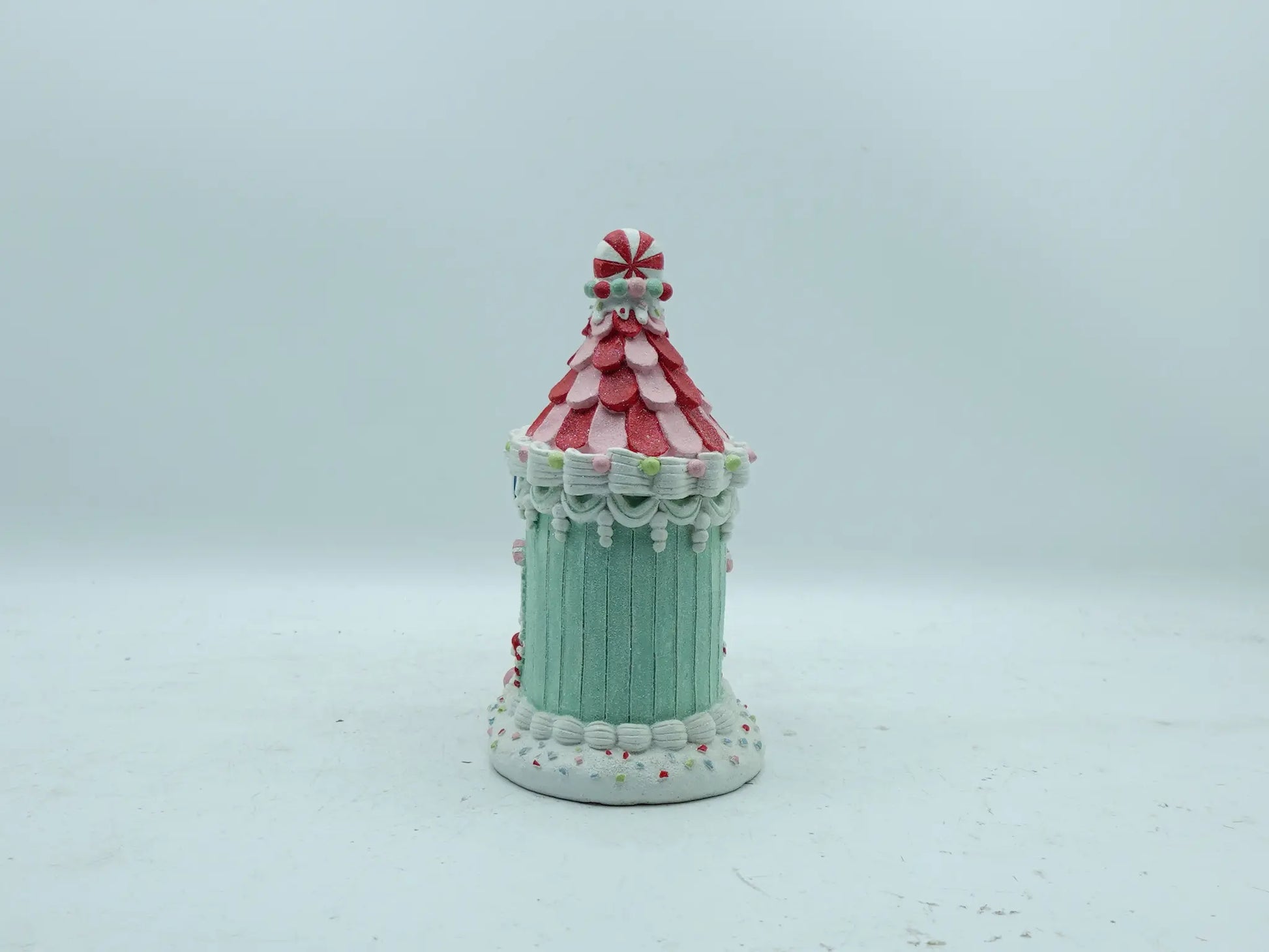Back view of the gingerbread house ornament showing mint-green paneled walls and icing swag details