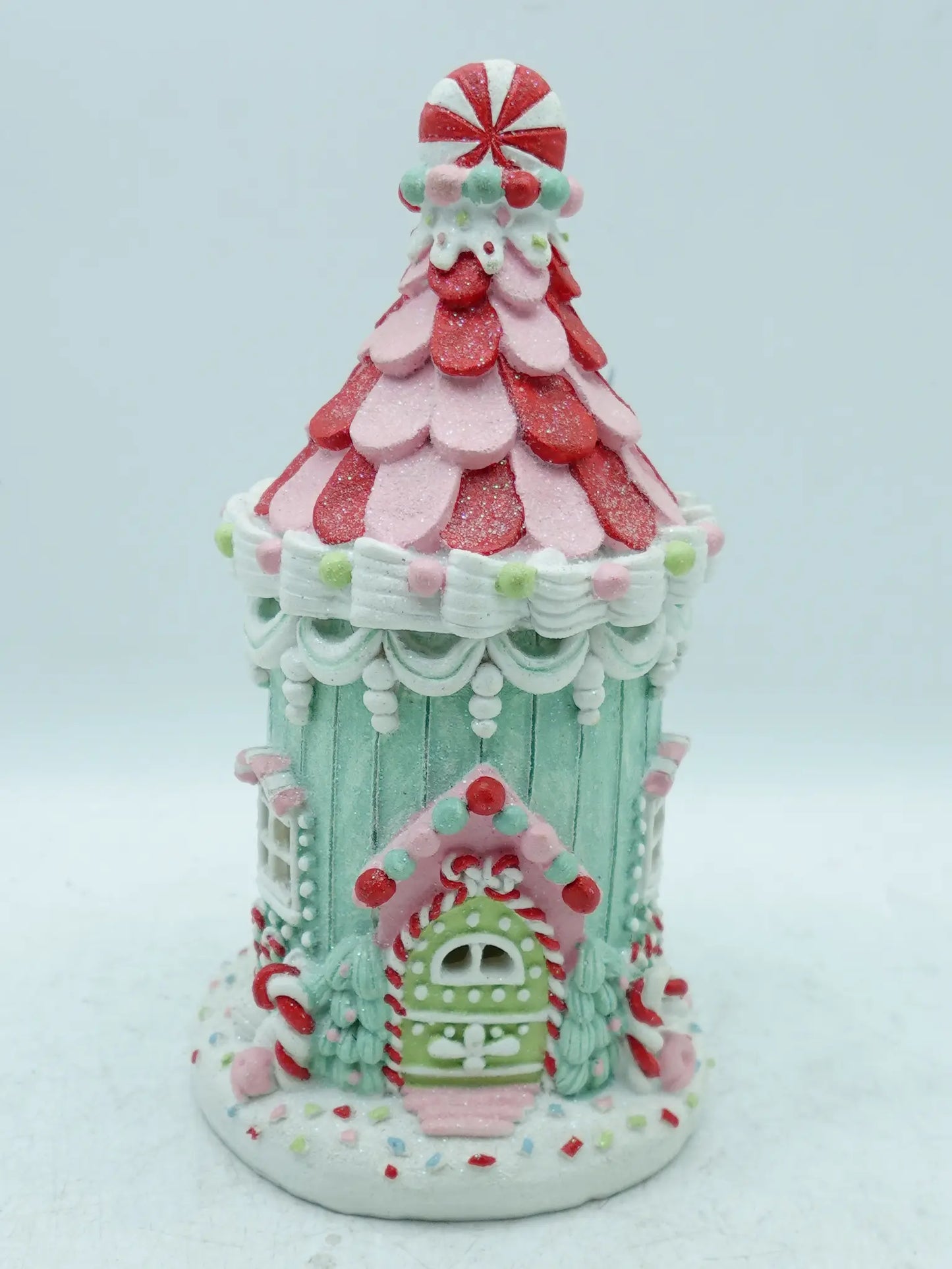 A decorative gingerbread house ornament or figurine, shown on a plain light background.