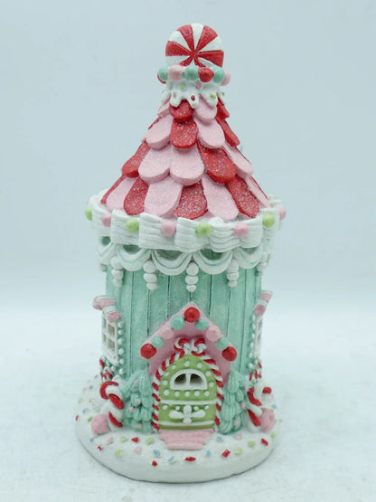 A decorative gingerbread house ornament or figurine, shown on a plain light background.
