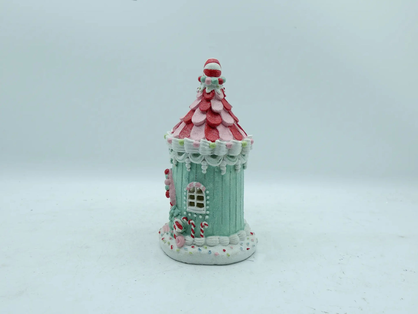 Side view of hand-painted candyland gingerbread house figurine with mint-green walls and peppermint candy roof