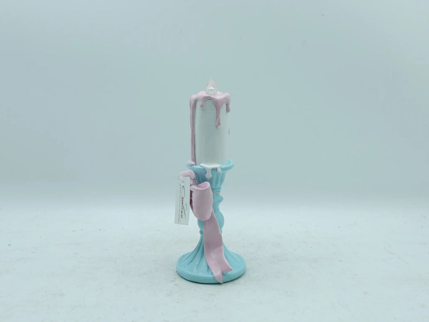 resin candle holder figurine displaying the flowing pink ribbon bow detail, side view