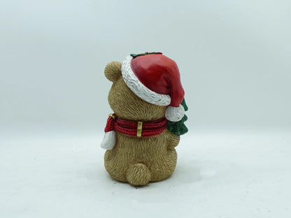 the teddy bear figurine showing the Santa hat pom-pom, scarf ends, and textured fur, back view 