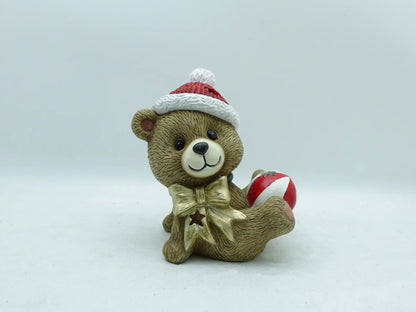 the hand-painted Christmas teddy bear with bauble figurine on clean gray background