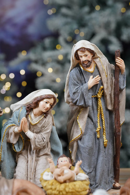 Holy Family close-up — kneeling Mary and standing Joseph with hand over heart against Christmas tree bokeh background