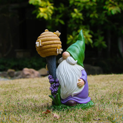 Whimsical bee gnome yard ornament in grass, beehive staff and lavender accent garden decor