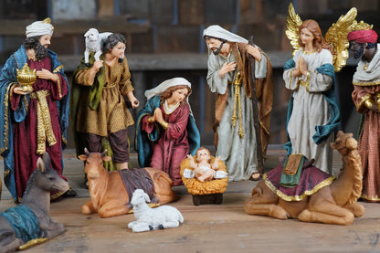Nativity set arranged on rustic surface, religious Christmas decor with Magi and angel