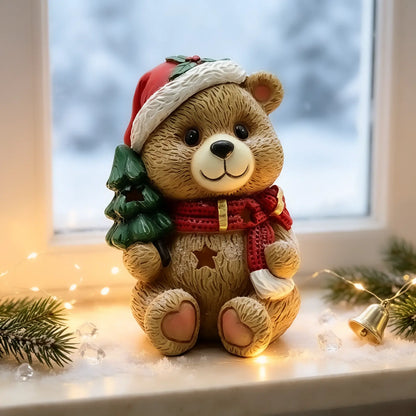 A decorative teddy bear figurine sits on a windowsill in a cozy holiday setting. 