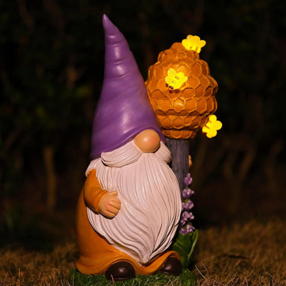 Lighted bee garden gnome statue holding honeycomb staff with glowing bee LED lights at night