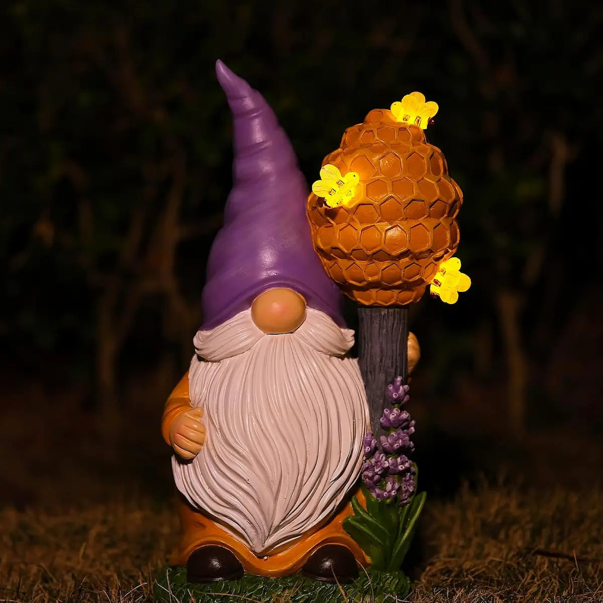 Whimsical garden gnome with honeycomb beehive topper and glowing bee lights, outdoor night decor.