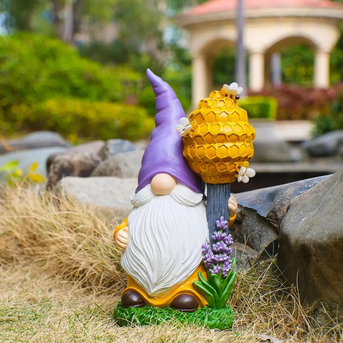 Outdoor gnome yard decor with honeycomb beehive staff and lavender accents in garden setting