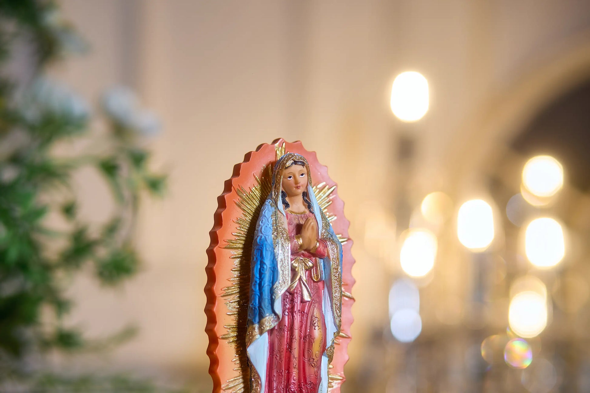 Our Lady of Guadalupe figurine face with blue starry mantle and gold halo, Close-up