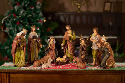 11-piece nativity figurine set on holiday Christmas table runner viewed from alternate angle in warm ambient light