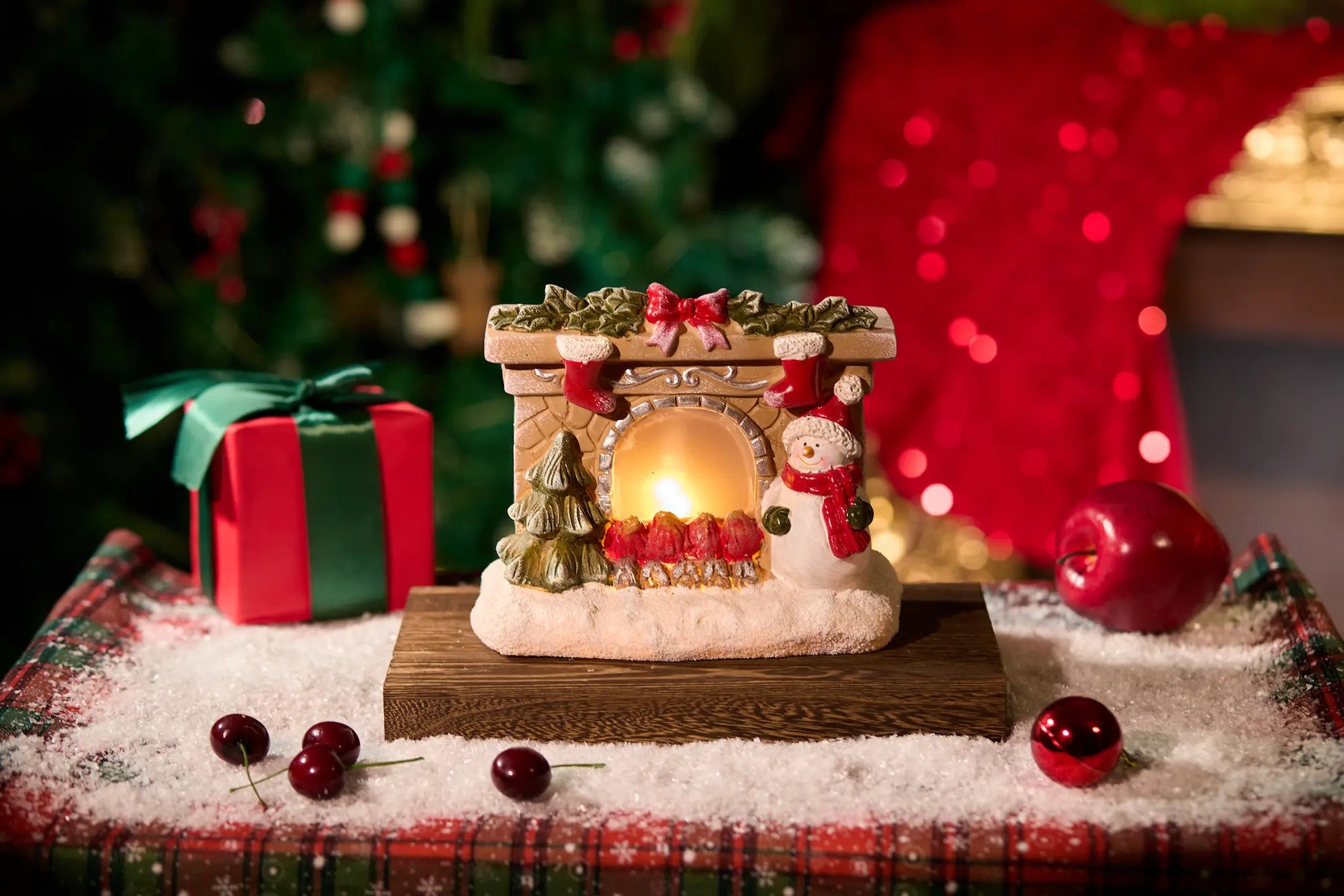 Lighted snowman fireplace figurine with LED glow on festive Christmas table setting