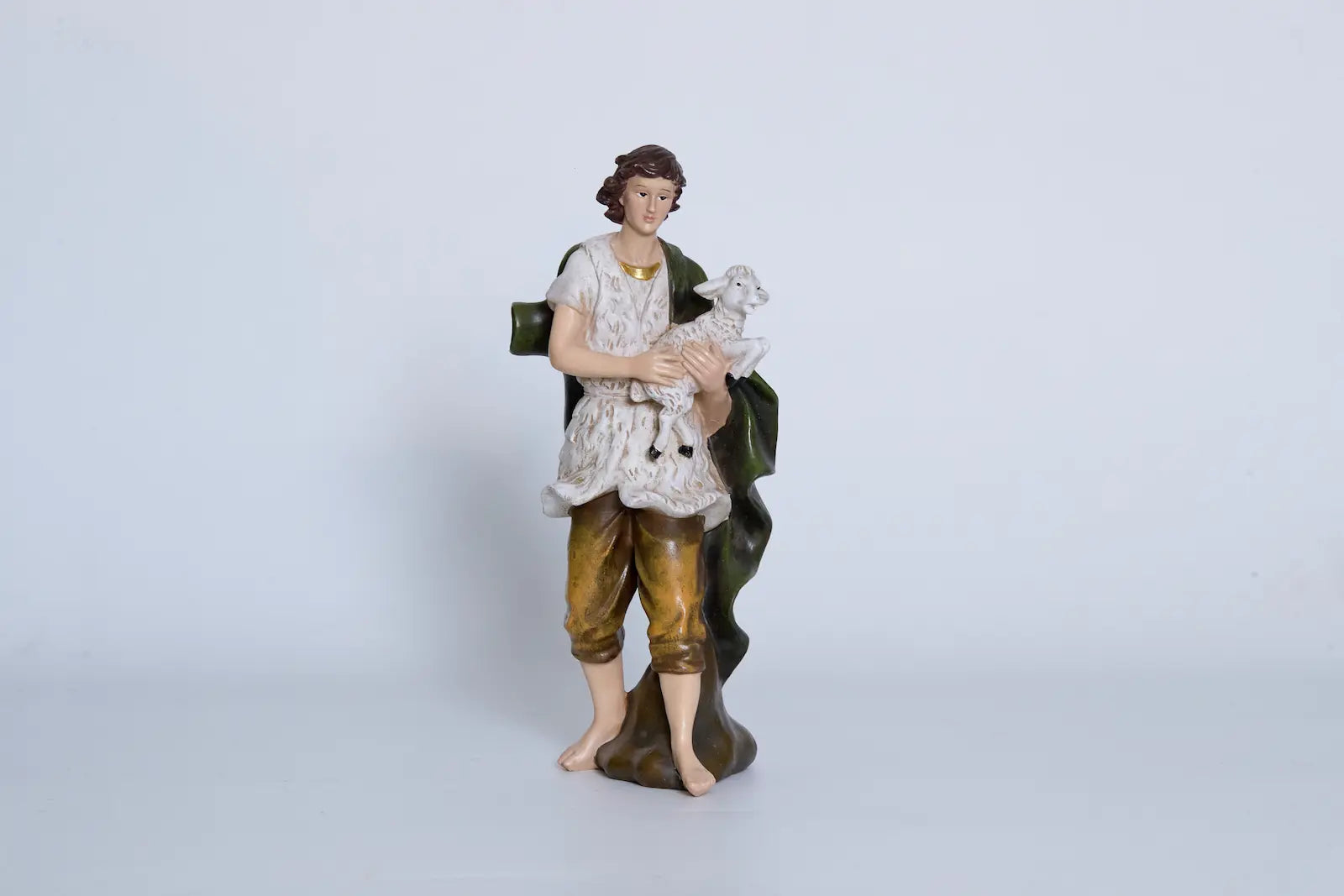Nativity shepherd holding lamb close-up — hand-painted resin figurine detail