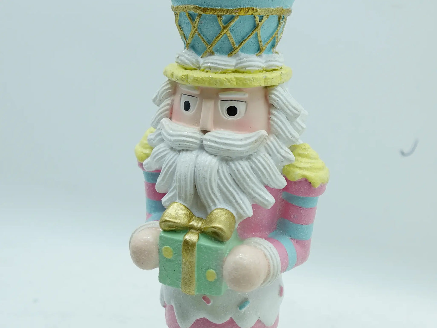 Close-up of the nutcracker's hand-painted face, white frosting beard, and gold-accented hat