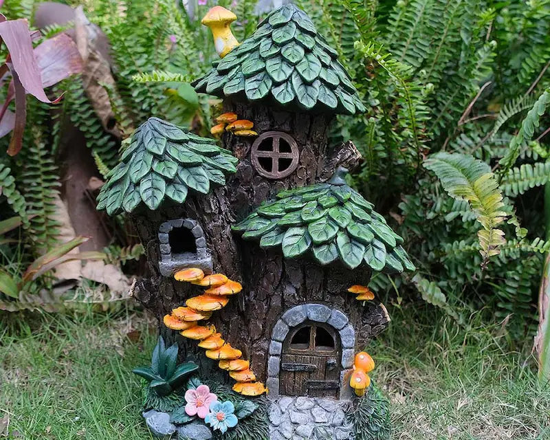 Outdoor fairy house displayed among green ferns and garden plants