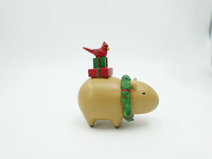 Christmas capybara figurine showing the red cardinal perched on gift boxes, angle view 